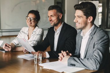 Grup hapy iş adamları resmi olarak Office masada oturan ve yeniden başlamak-in yeni personel iş görüşmesi sırasında - iş, kariyer ve yerleşim kavramı inceleyerek uygun