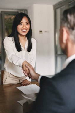İş, kariyer ve yerleşim kavramı - erkek baş yönetmen veya büyük şirket başarılı anlaşmalar veya röportaj sonra işveren ile mutlu Asyalı kadın el sıkışma