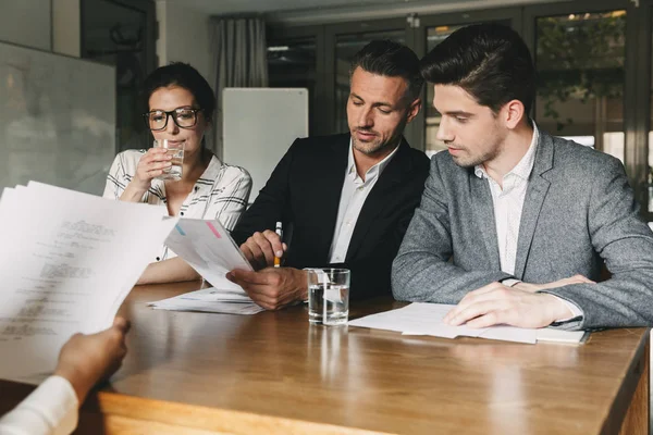 Grupo Empregadores Caucasianos Desgaste Formal Sentados Mesa Escritório Consultando Jovem — Fotografia de Stock