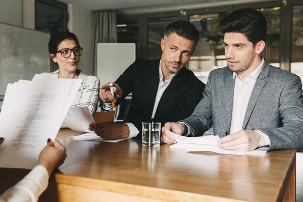 职业和安置概念 三位执行董事或主管经理坐在桌上和面试妇女在公司的团队合作 — 图库照片