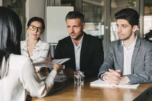 İş, kariyer ve yerleşim kavramı - üç İcra Direktörleri veya Office masada oturan ve yeniden başlamak-in kadın işçi inceleyerek baş yöneticileri