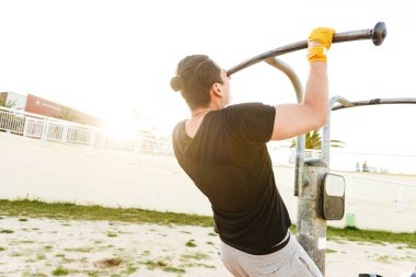 Açık havada bir kenara seyir egzersizleri yapmak imge-in güçlü yakışıklı genç sporcu.