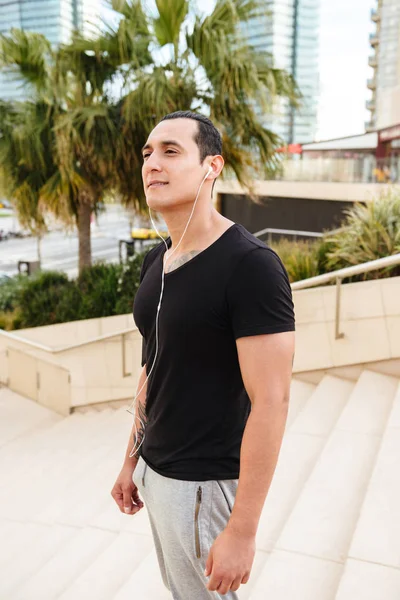 Yakışıklı genç sporcu bir kenara açık havada kulaklık arıyorum portresi.