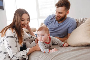 Mutlu genç aile görüntüsü. Having oyunculuk ile küçük çocuklarının kapalı evde anne.