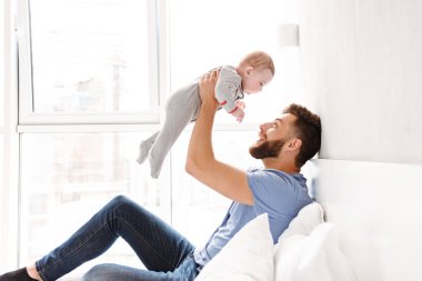 Mutlu yakışıklı genç baba baba küçük bebek çocuk oğlu ile kapalı evde eğlenmek fotoğrafı.