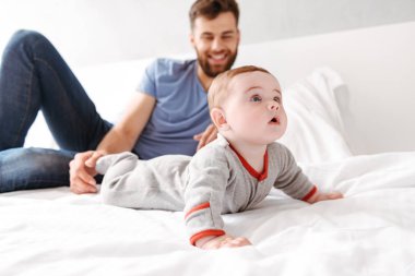 Mutlu yakışıklı genç baba baba küçük bebek çocuk oğlu ile kapalı evde eğlenmek fotoğrafı.