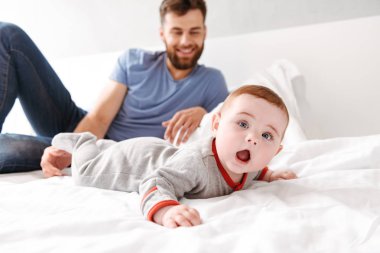 Mutlu yakışıklı genç baba baba küçük bebek çocuk oğlu ile kapalı evde eğlenmek fotoğrafı.