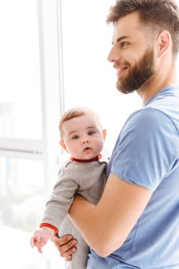 Onun küçük oğlu çocuğu bir kenara arıyorum elinde tutan adam yakışıklı genç neşeli görüntüsünü sakallı.