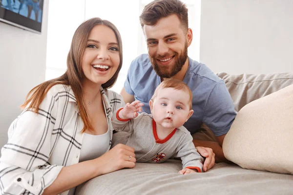 Mutlu genç aile görüntüsü. Having oyunculuk ile küçük çocuklarının kapalı evde anne.