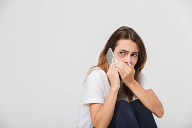 Beyaz arka plan üzerinde izole cep telefonunuzla aramayı yüzünde yaralar korkmuş kadınla istismar