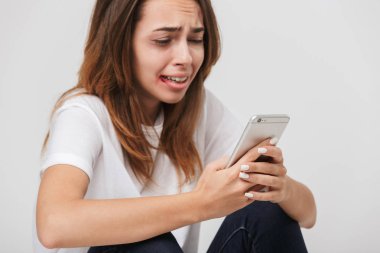 Beyaz arka plan üzerinde izole cep telefonunuzla aramayı yüzünde yaralar korkmuş kadınla istismar