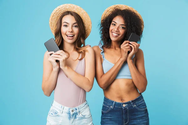 Две Милые Многоэтнические Женщины Лет Соломенных Шляпах Улыбающиеся Держащие Смартфон — стоковое фото
