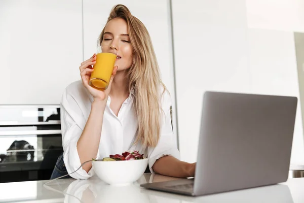 Glad Ung Kvinna Äter Sallad Från Skål Och Dricker Apelsinjuice — Stockfoto