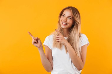 Sarı arka plan üzerinde izole kopya alanı gösteren gülümseyen genç sarışın kız portresi