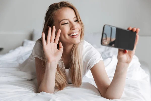 Фотографія Молодої Щасливої Милої Жінки Лежить Ліжку Вдома Використовуючи Мобільний — стокове фото