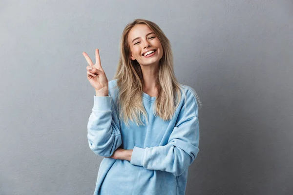 Portrait Cheerful Young Girl Blue Sweatshirt Showing Peace Gesture Isolated — Stock Photo, Image