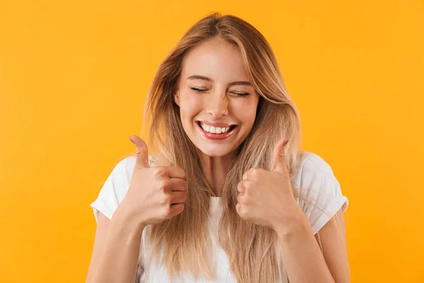 一个快乐的年轻金发女孩的肖像显示两个大拇指 闭上眼睛封闭的黄色背景 — 图库照片