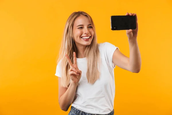 Wesoły Młoda Blondynka Pokazuje Gest Pokoju Podczas Robienia Selfie Telefonu — Zdjęcie stockowe