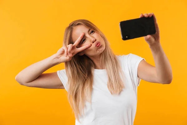 Счастливая Молодая Блондинка Показывает Жест Мира Делая Селфи Мобильного Телефона — стоковое фото