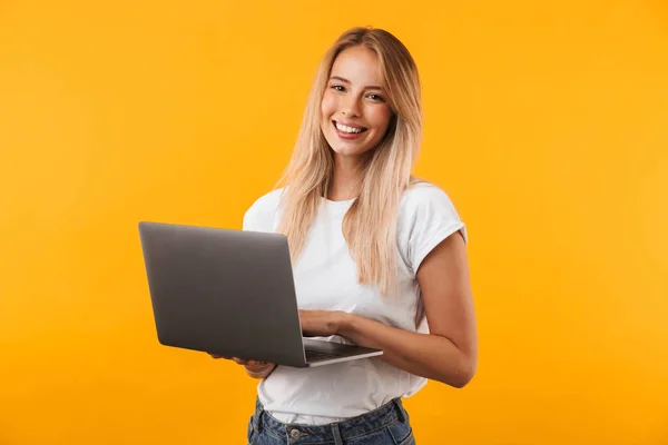 Dizüstü Bilgisayar Üzerinde Sarı Arka Plan Izole Tutmak Gülümseyen Genç — Stok fotoğraf