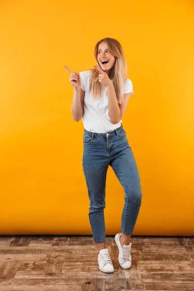 Full Length Portrait Joyful Young Blonde Girl Pointing Copy Space — Stock Photo, Image