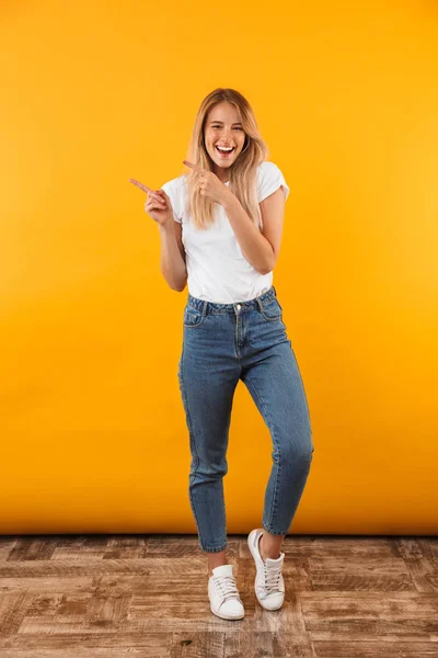 Full Length Portrait Cheerful Young Blonde Girl Pointing Copy Space — Stock Photo, Image