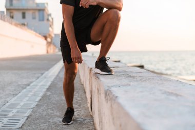 Plajda germe egzersizleri yapıyor kulaklık ile sporcu görüntü kırpılmış