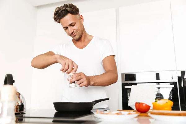 Bonito Homem Cozinhar Ovos Para Café Manhã Enquanto Uma Cozinha — Fotografia de Stock