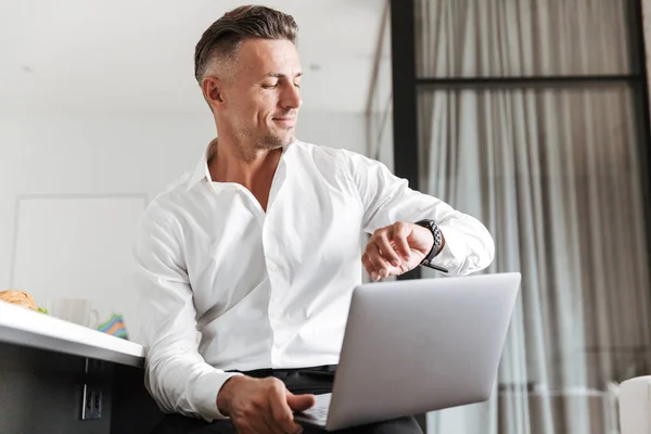 Hombre Sonriente Vestido Con Ropa Formal Usando Portátil Mirando Reloj — Foto de Stock