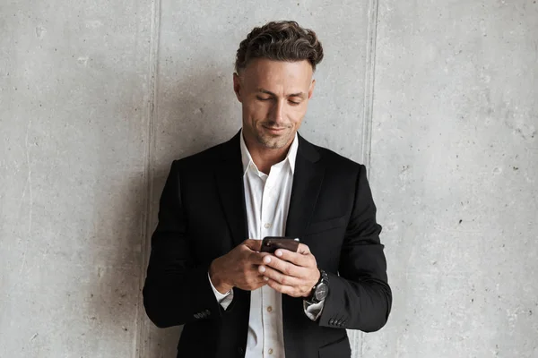 Handsome Man Dressed Suit Holding Mobile Phone Gray Wall Background — Stock Photo, Image