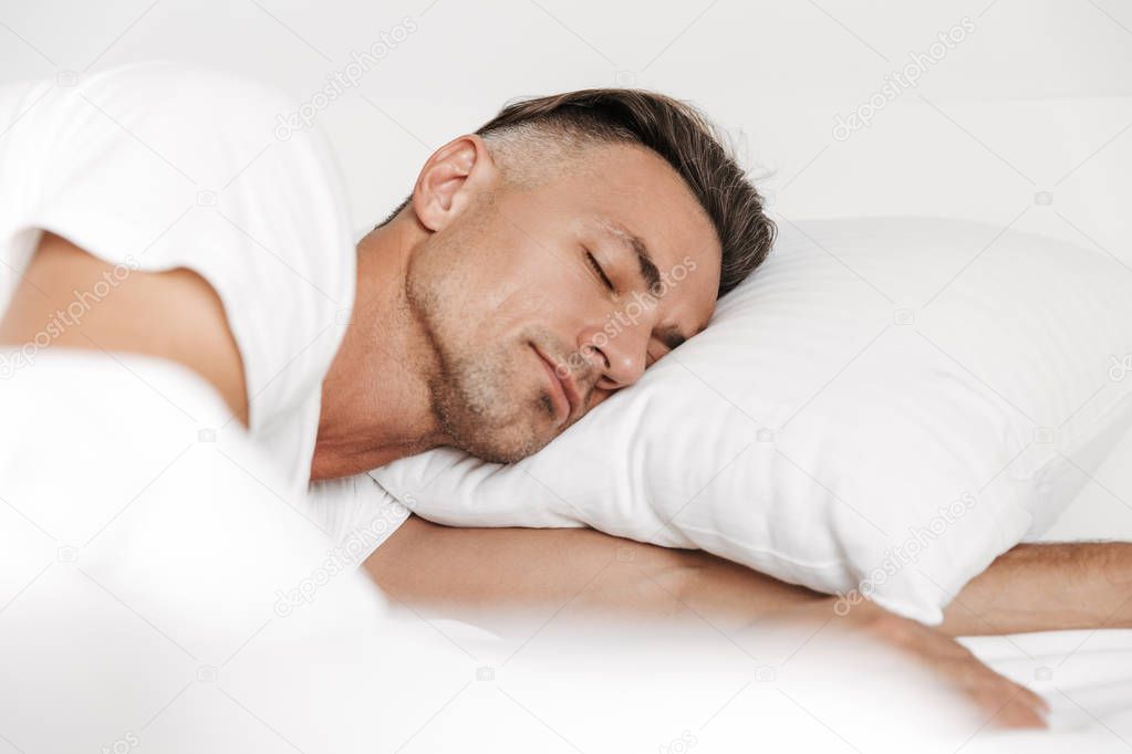 Handsome man sleeping in bed at home