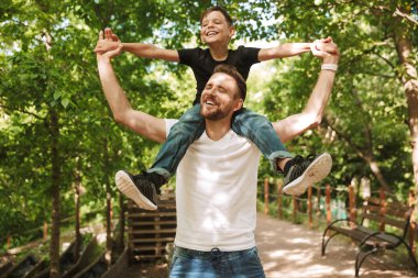 Mutlu genç baba resim var eğlenceli küçük oğlu ile açık havada park doğada.