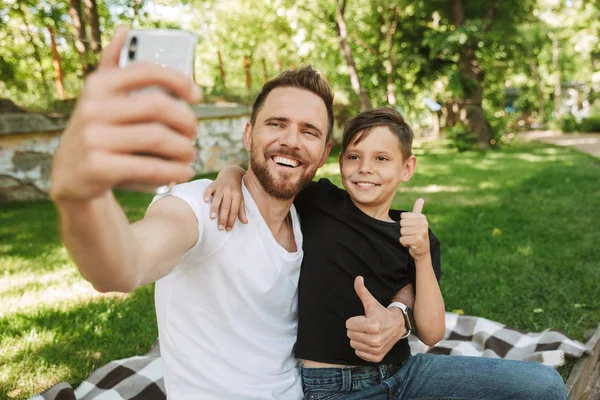 Imagem Pai Jovem Feliz Sentado Com Seu Filho Pequeno Livre — Fotografia de Stock