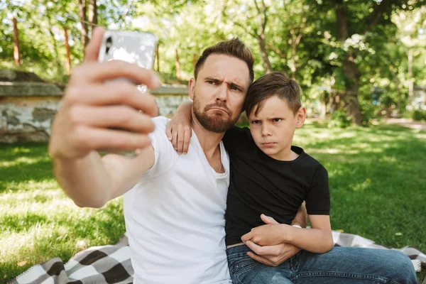 Imagem Jovem Pai Engraçado Sentado Com Seu Filho Pequeno Livre — Fotografia de Stock