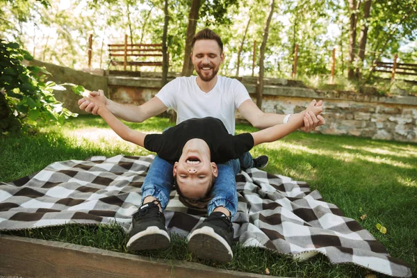 Mutlu genç baba resim var eğlenceli küçük oğlu ile açık havada park doğada.