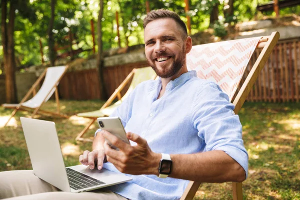 Imagem Jovem Barbudo Feliz Livre Usando Computador Portátil Telefone Móvel — Fotografia de Stock