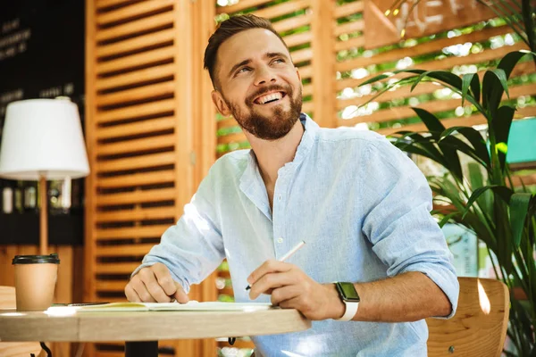 Görüntü Genç sakallı adam açık havada bir kenara arıyorum Not yazma.