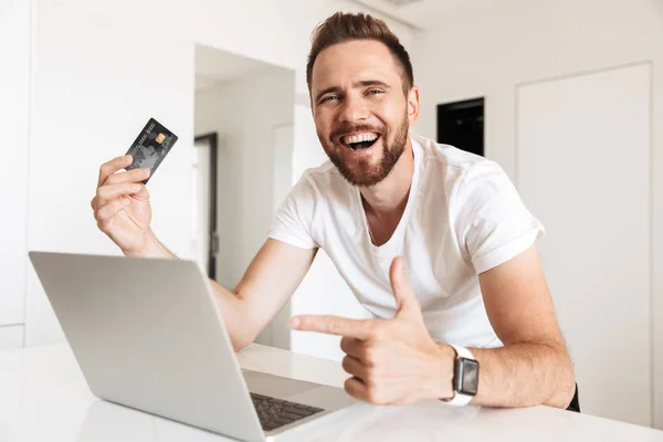 Foto Joven Emocional Usando Ordenador Portátil Con Tarjeta Crédito Interior —  Fotos de Stock