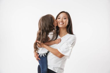 Beyaz duvar arka plan üzerinde izole küçük kız çocuk kızı annesiyle mutlu Genç Asyalı kadın görüntüsünü.