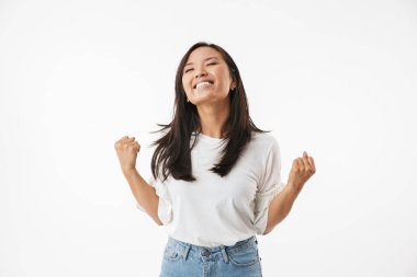 Heyecanlı genç ve güzel Asyalı kadın kazanan jest gösterilen beyaz duvar arka plan üzerinde izole görüntüsünü.