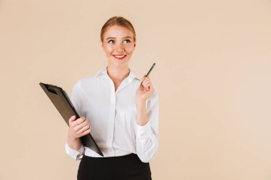 Pano tutan bej duvar artalan üzerinde izole genç mutlu iş kadını görüntüsü. Kenara işaret arıyorum.