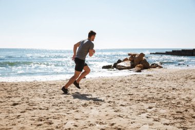 Bir kum üzerinde koşu sağlıklı genç sporcu