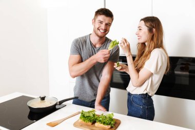 Genç çift birlikte sandviç yemek gülen ve having fun