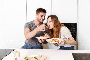 Genç çift birlikte bir mutfakta kahvaltı gülümseyen