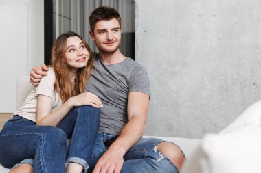 Mutlu genç çift birlikte evde bir kanepede otururken sarılma