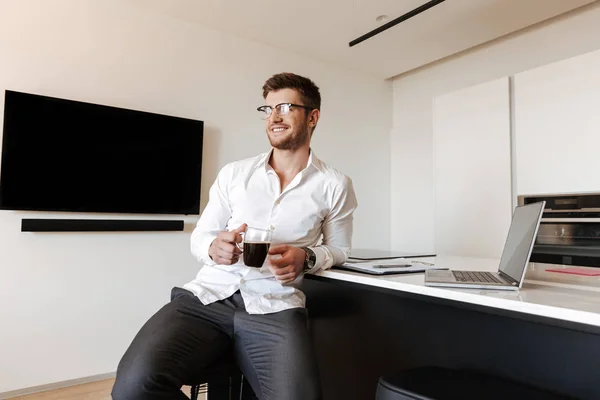 Dizüstü Bilgisayar Evde Belgeleri Ile Çalışırken Içme Kahve Yakışıklı Genç — Stok fotoğraf