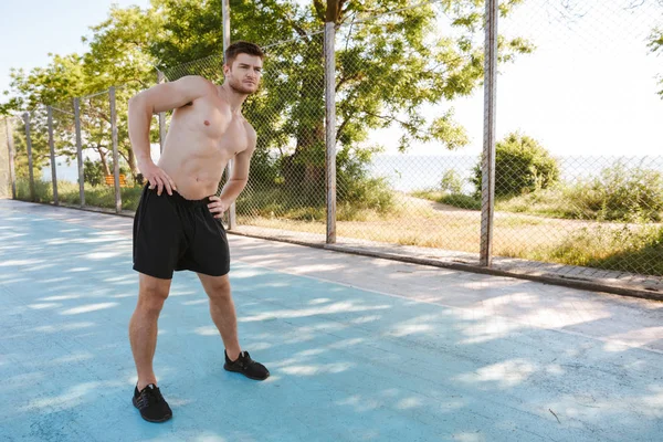 Açık havada bir oyun üzerinde germe egzersizleri yapıyor sporcu odaklı