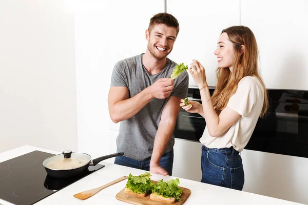 Genç çift birlikte sandviç yemek gülen ve having fun