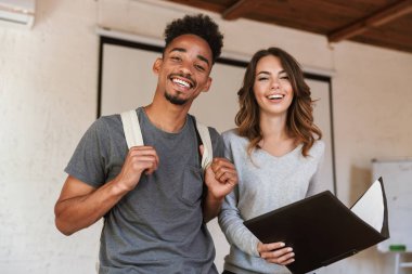 Mutlu arkadaş öğrenciler sınıfta klasörü okuma tutan görüntüsü. Görünümlü kamera.