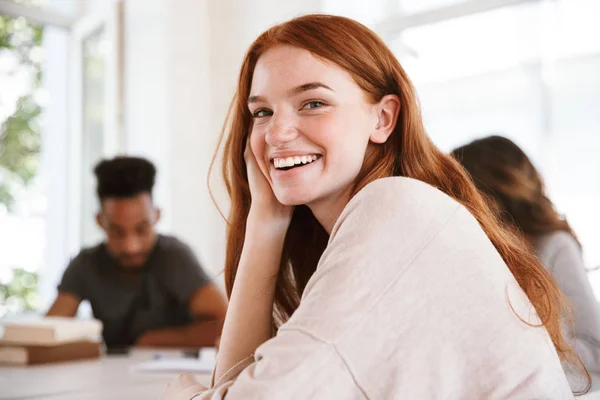 Imagem Jovem Senhora Ruiva Feliz Olhando Câmera Enquanto Seus Amigos — Fotografia de Stock